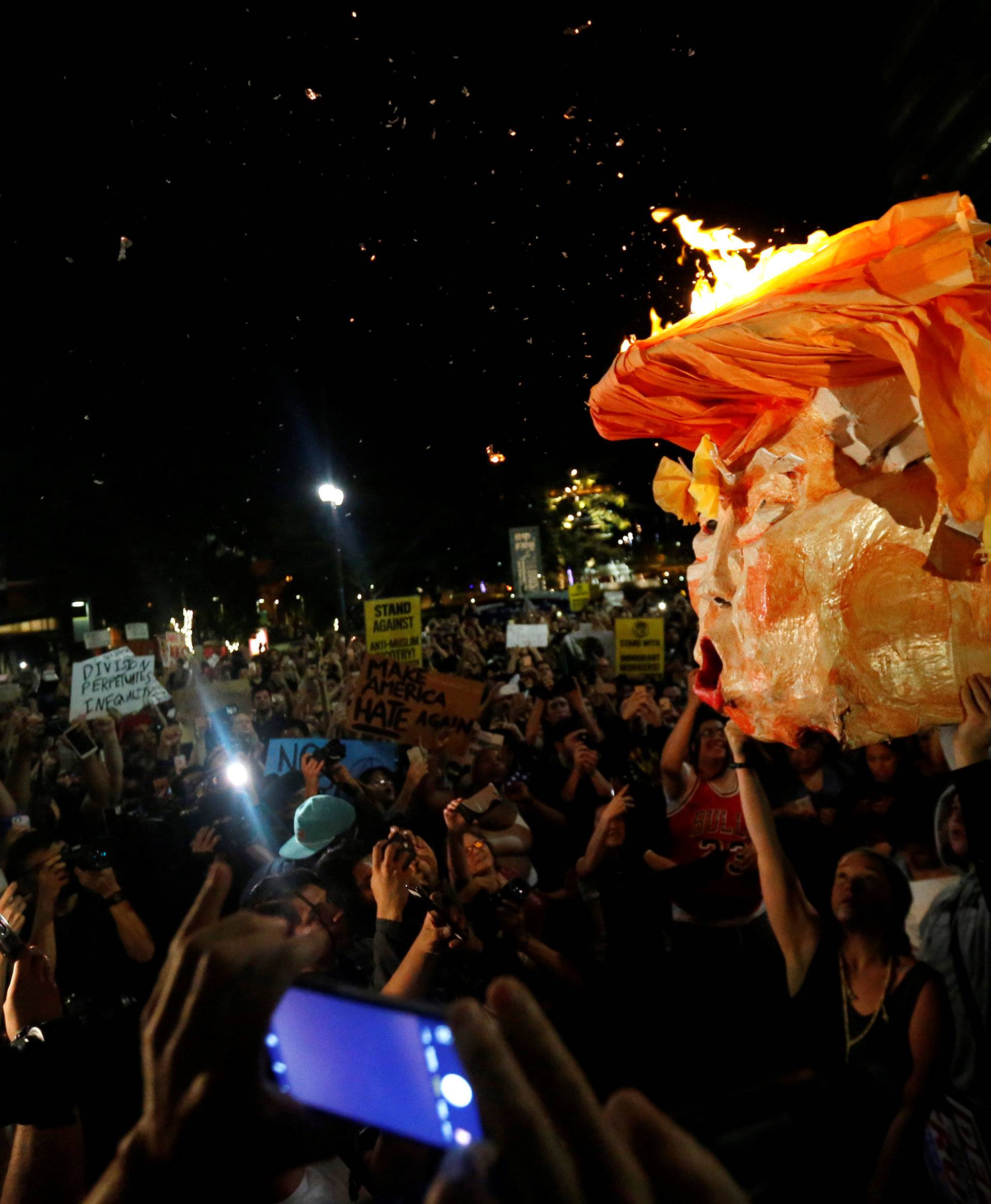 People hold a pinata which was lit on fire while protesting the election of Republican Donald Trump as the president of the United States in downtown Los Angeles