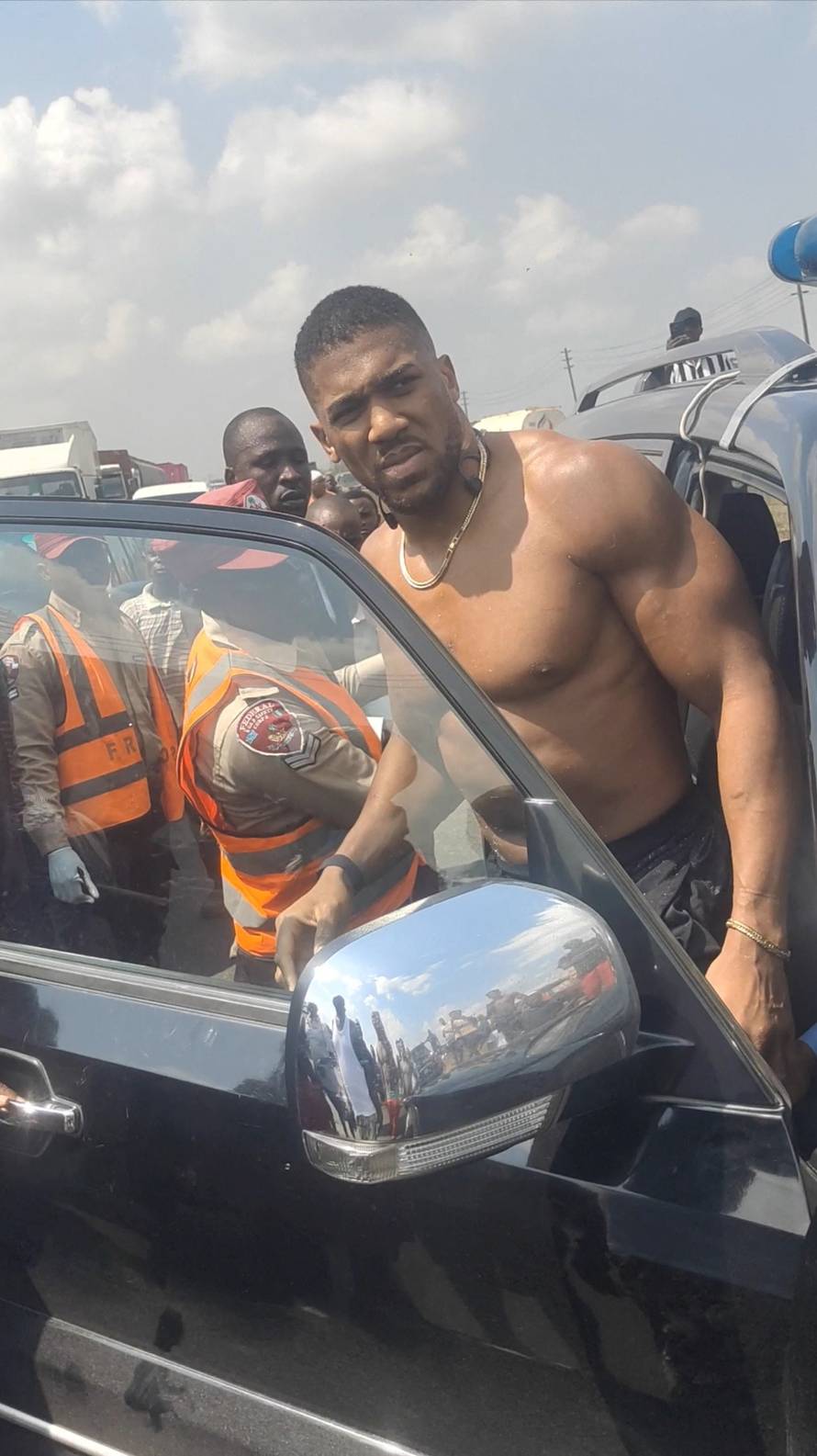 Former heavyweight boxing champion Anthony Joshua looks on as he gets on a vehicle following a car accident, near Sagamu