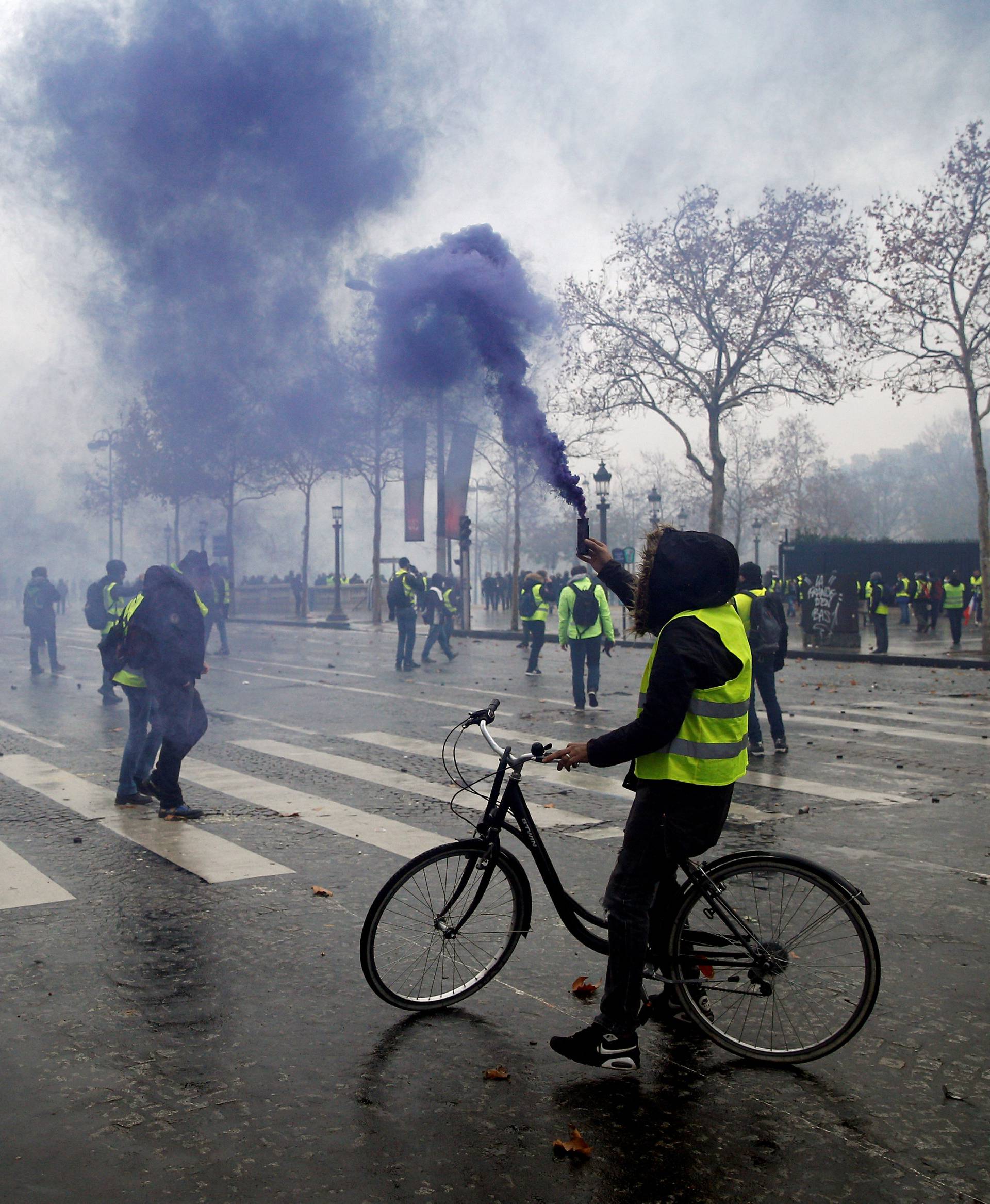 Protesters wearing yellow vests, a symbol of a French drivers' protest against higher diesel taxes, face off with French riot police during clashes at the Place de l'Etoile near the Arc de Triomphe in Paris