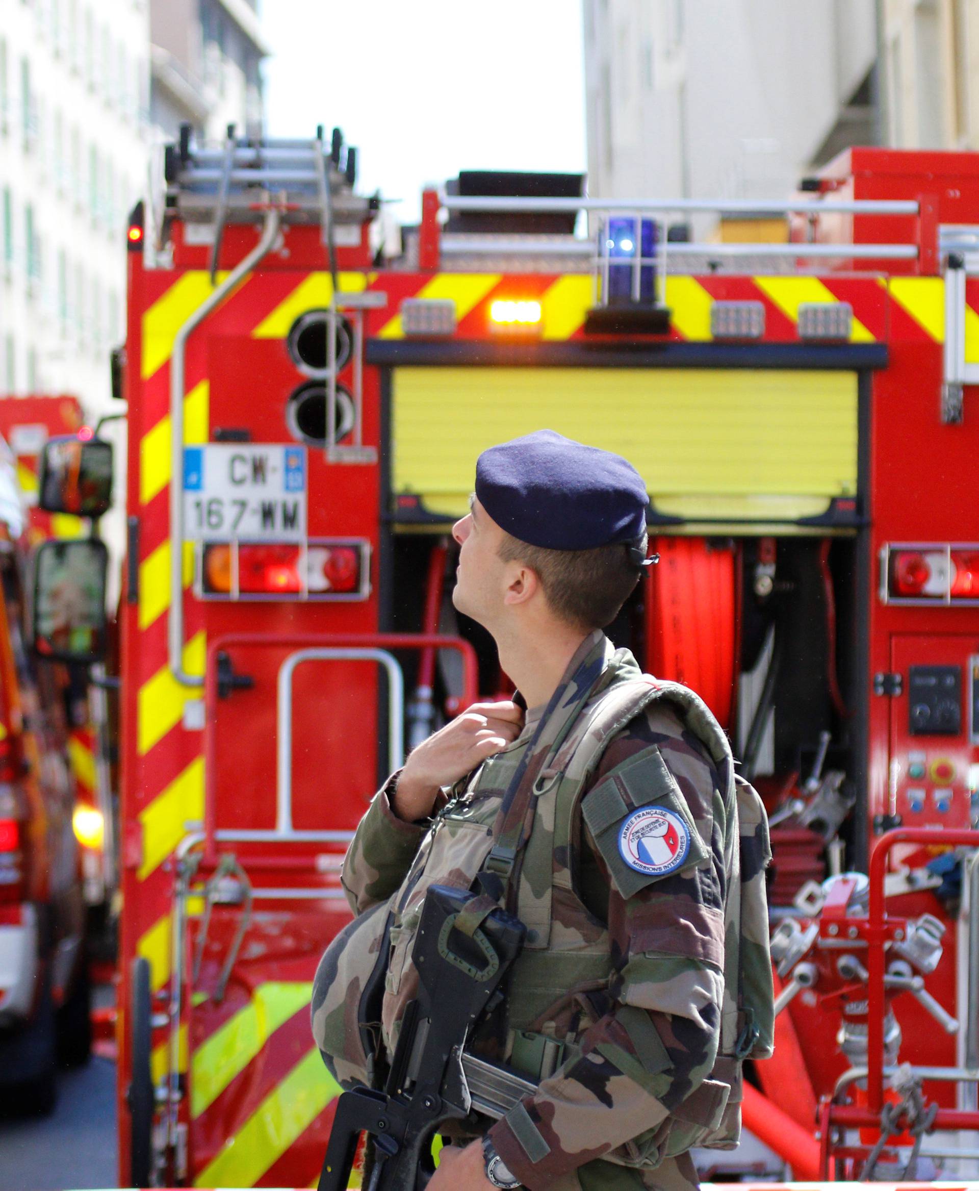 French firefighters and soldiers secure the street as police conduct an investigation after two Frenchmen were arrested in Marseille