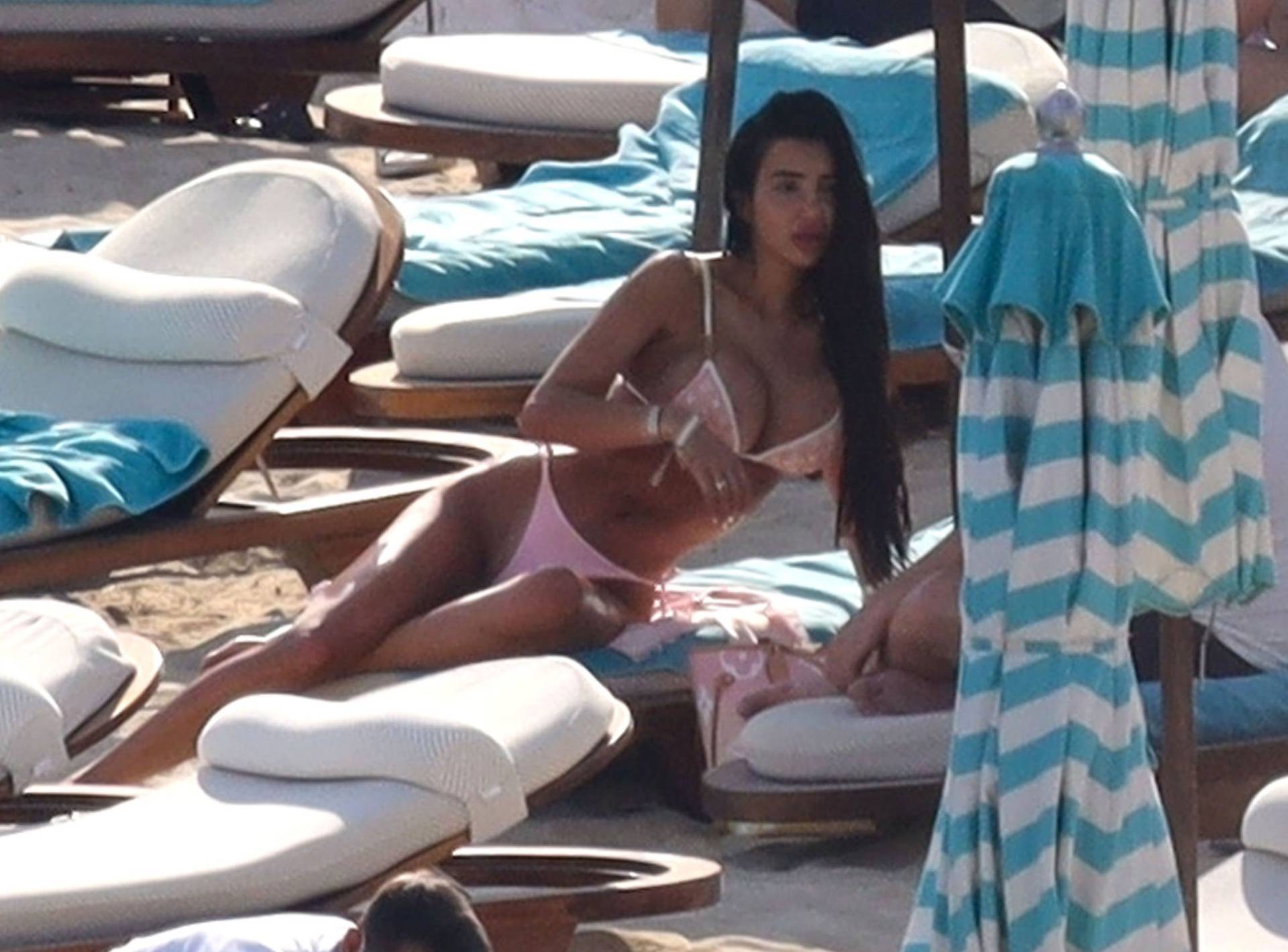 *EXCLUSIVE* the British Glamour Model Chloe Khan puts on a busty display in a tiny pink bikini with a flirty display with a mystery man on holiday in Mykonos.