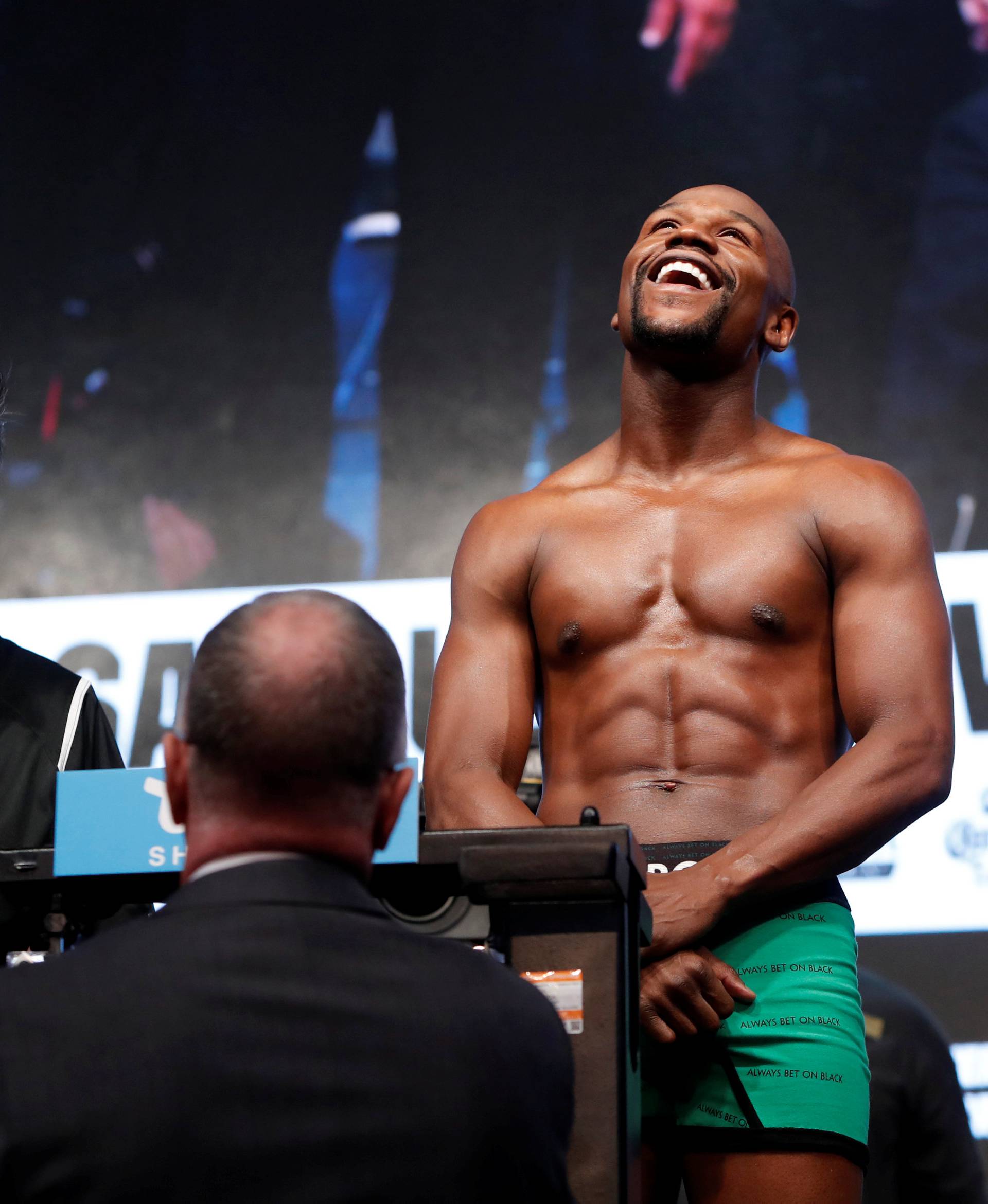 Undefeated boxer Floyd Mayweather Jr. of the U.S. smiles on the scale during his official weigh-in at T-Mobile Arena in Las Vegas