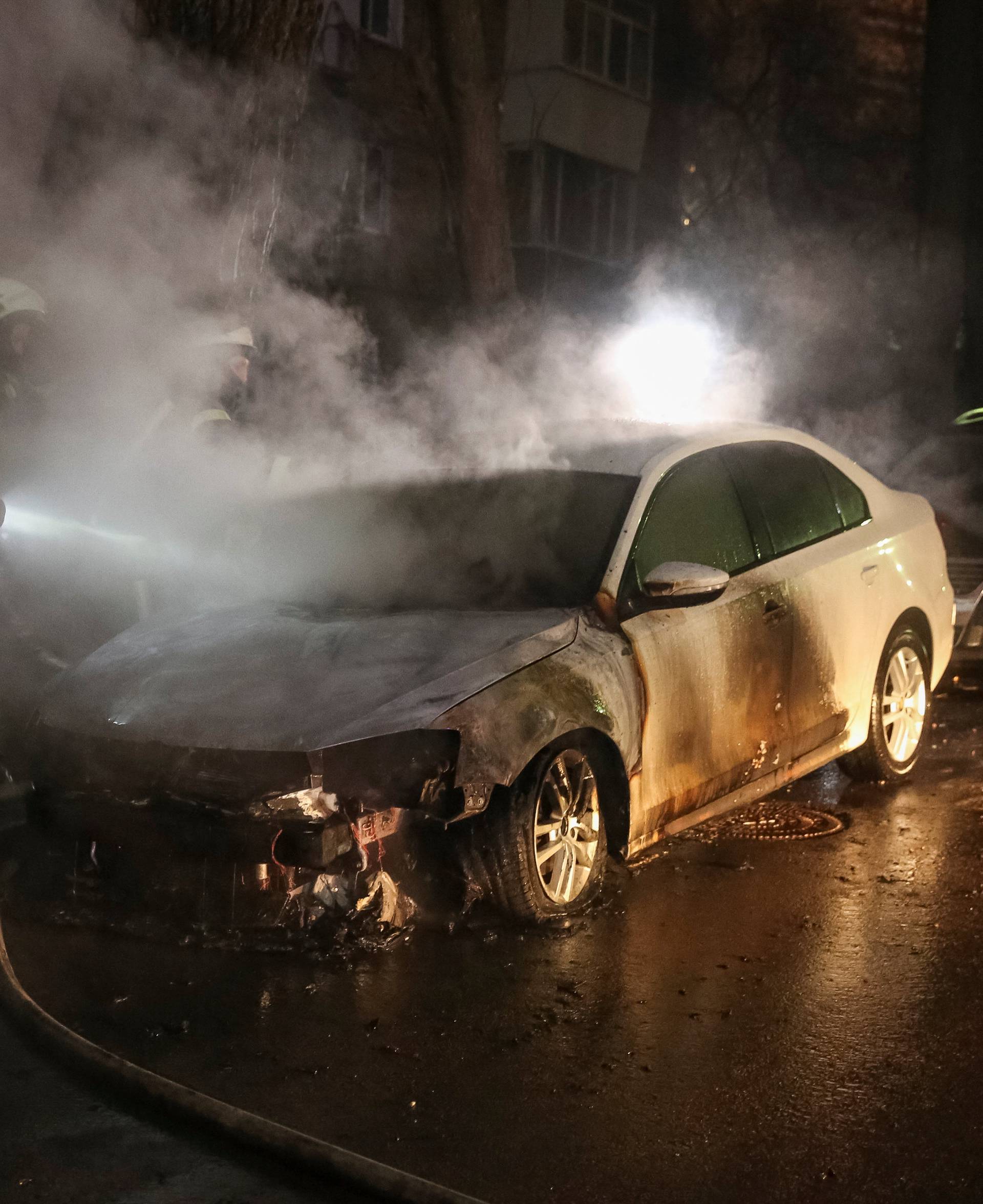 Firefighters extinguish a burning car of the embassy of Russia after a rally against the seizure by Russian special forces of three of the Ukrainian navy ships in the Black Sea, in front of the Russian embassy in Kiev