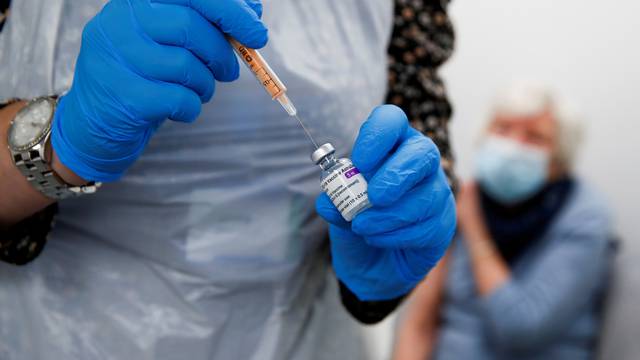 FILE PHOTO: A health worker fills a syringe with a dose of the Oxford/AstraZeneca COVID-19 vaccine
