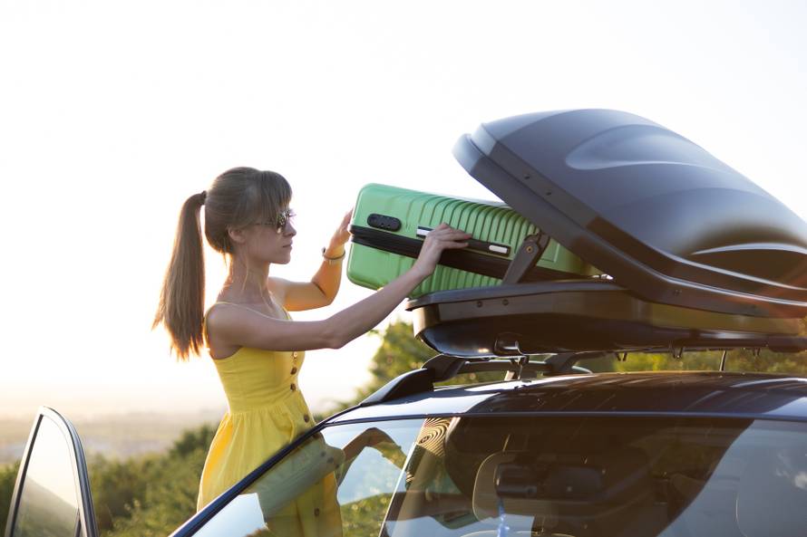 Young,Woman,Taking,Green,Suitcase,Out,From,Car,Roof,Rack.