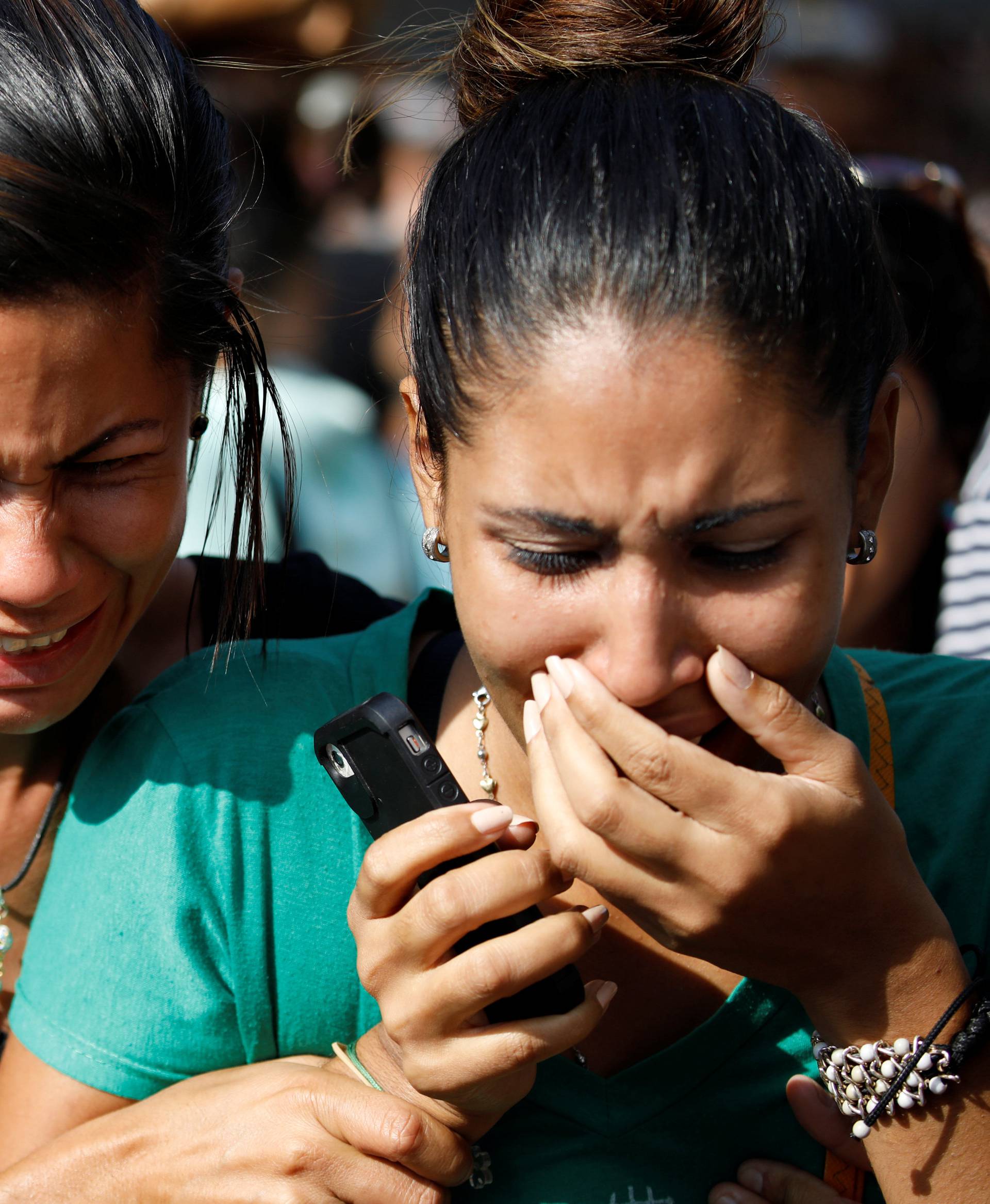 Relatives of inmates at the General Command of the Carabobo Police react as they wait outside the prison in Valencia