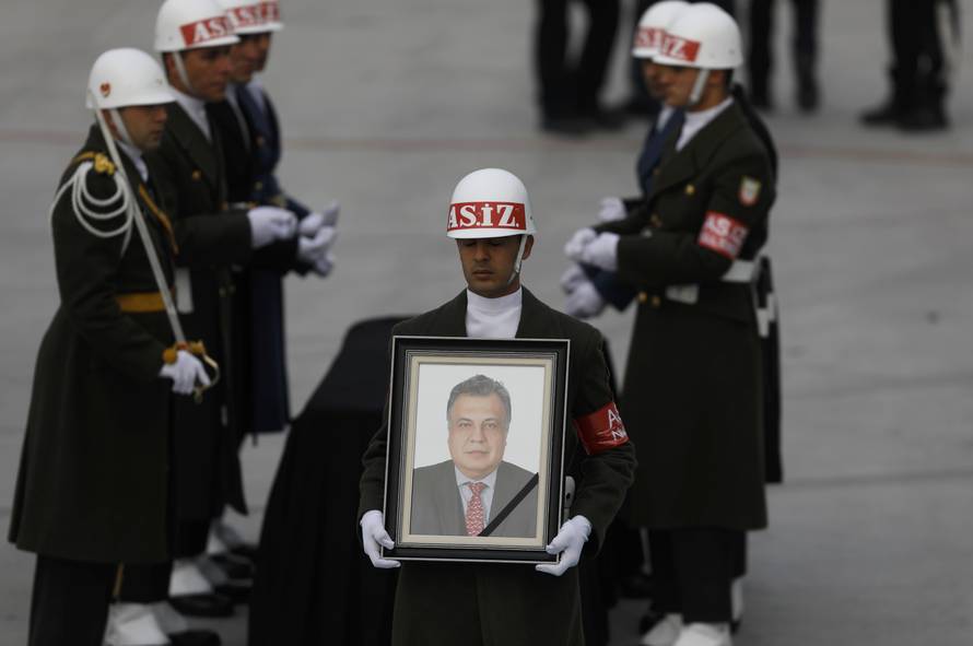 Honor guard holds a picture of late Russian Ambassador to Turkey Karlov during a ceremony at Esenboga airport in Ankara