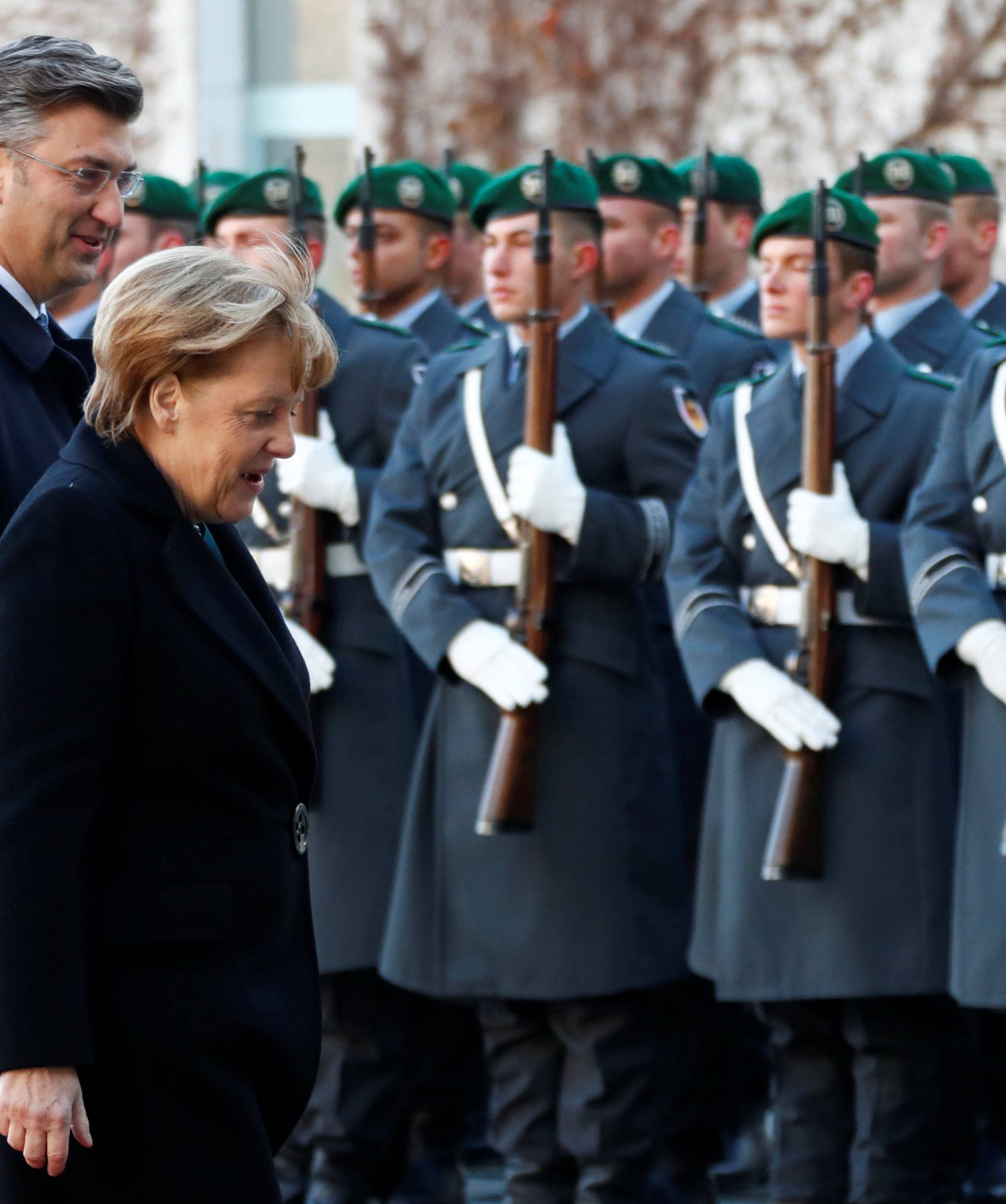 Croatia's Prime Minister Plenkovic and German Chancellor Merkel review the honor guard during a welcoming ceremony in Berlin