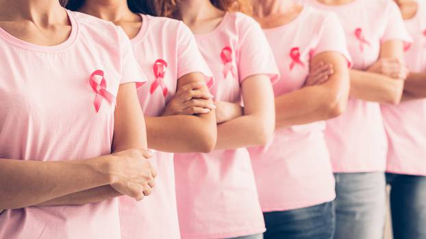 Unrecognizable Ladies In Cancer Awareness T-Shirts Posing Over White Background