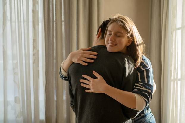 A couple in romantic relationship, girl warm hugs a man.
