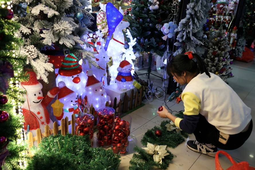 FILE PHOTO: A staff member assembles a Christmas decoration at a booth in a mall in Beijing