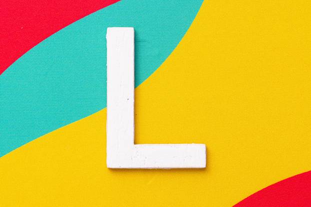 Letter L of the alphabet on colored background, top view