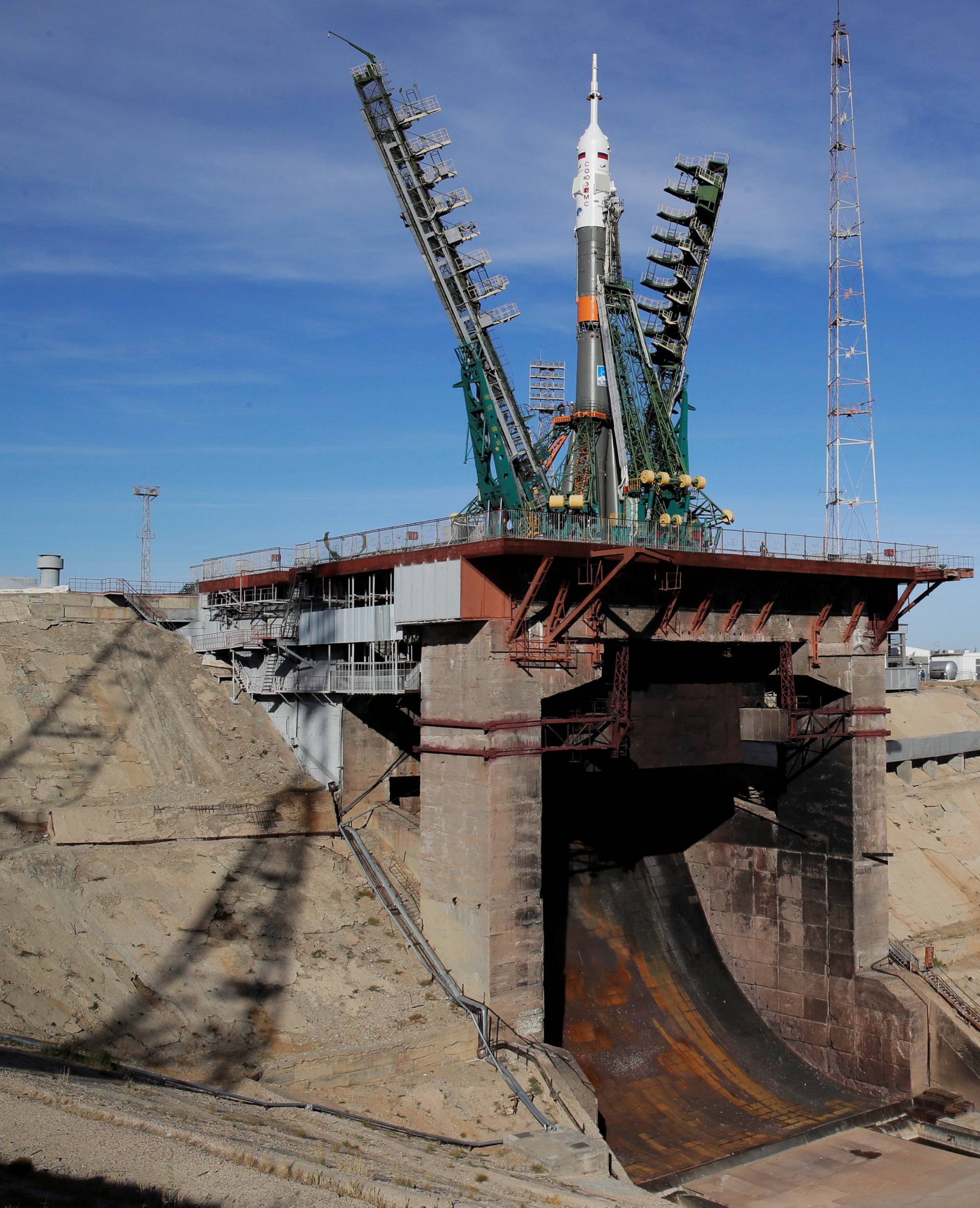 Service towers move towards Russia's Soyuz-FG booster rocket with the Soyuz MS-10 spacecraft at the launch pad at Baikonur Cosmodrome