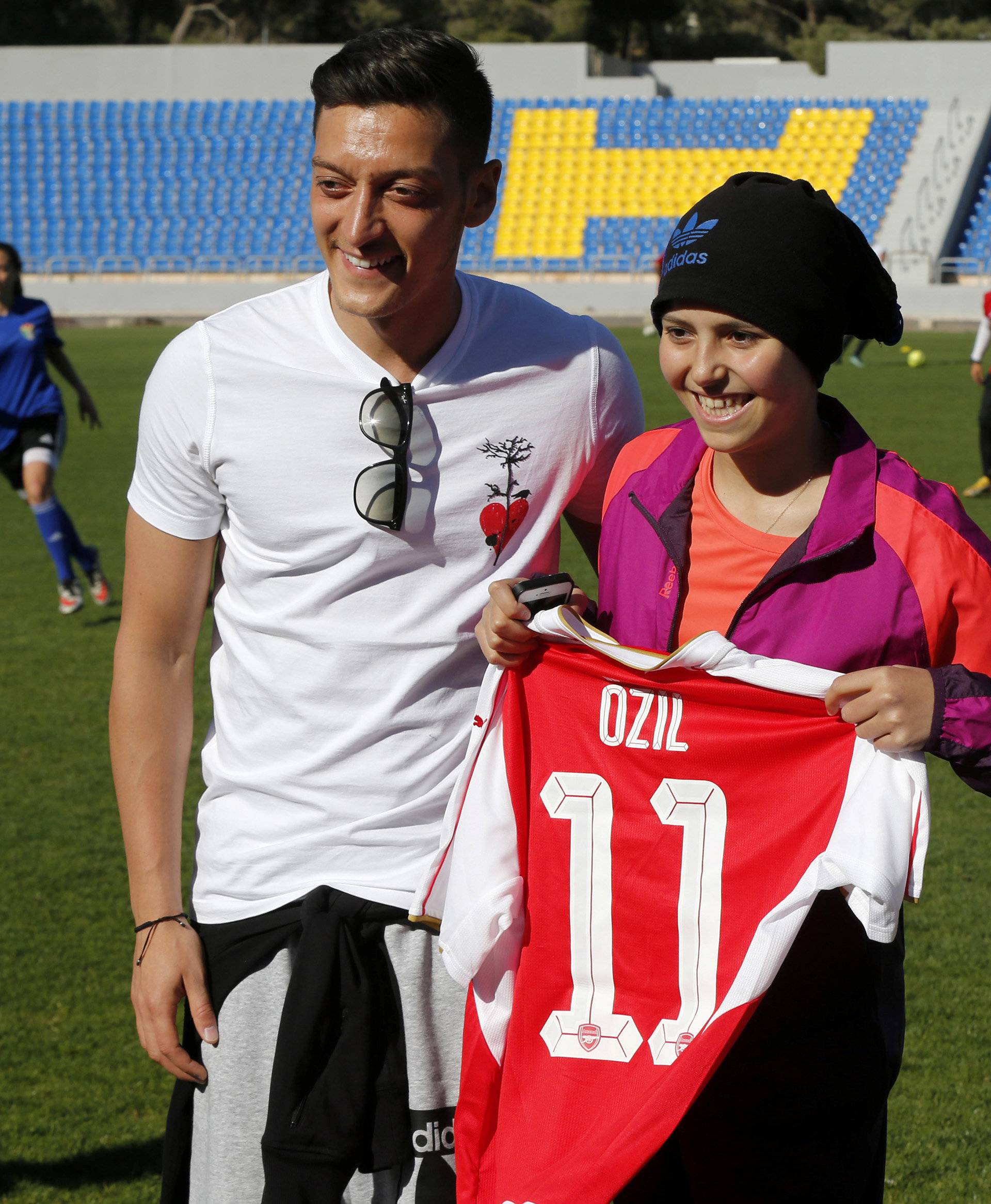 Germany and Arsenal player Ozil and Jordan's Prince Ali Bin Al Hussein President of the Jordan Football Association and Founder and Chairman of AFDP, pose with Jordanian cancer patient player Rama Al-Qadi in Amman
