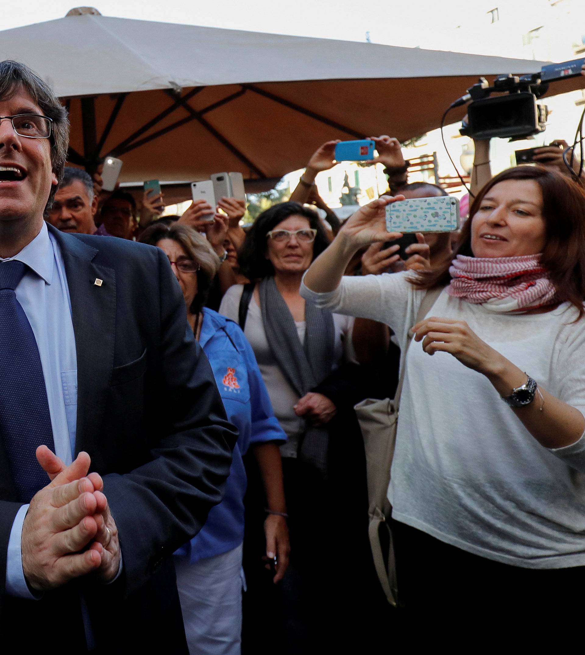 FILE PHOTO: Sacked Catalan President Carles Puigdemont gestures after leaving a restaurant the day after the Catalan regional parliament declared independence from Spain in Girona