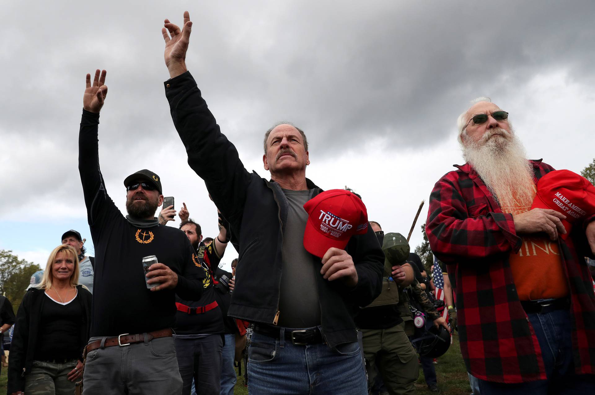 People raise their hands during a rally of the far right group Proud Boys, in Portland