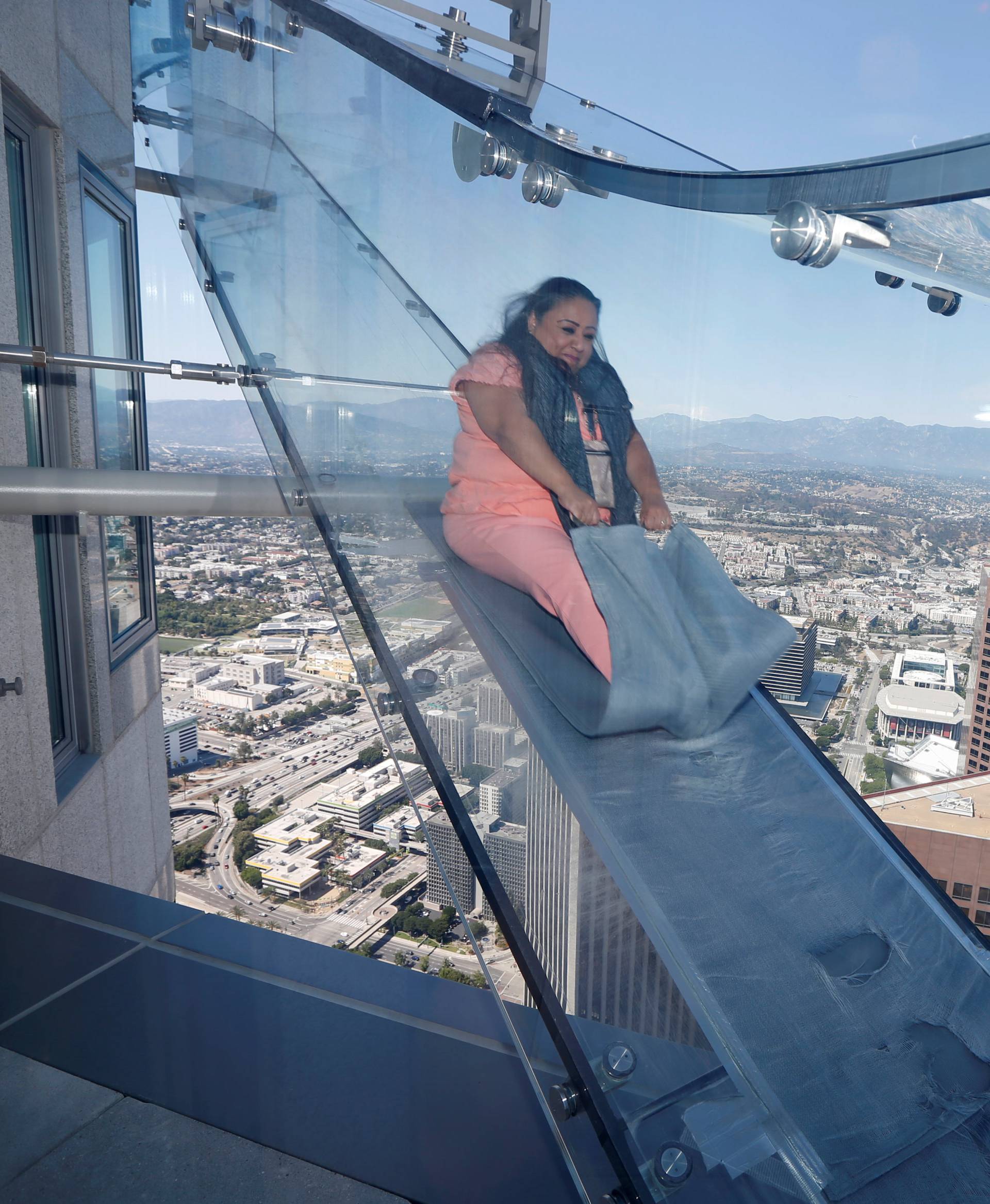 Patricia Rodriguez, 49, rides the Skyslide on the 69th and 70th floors of the U.S. Bank Tower which is attached to the OUE Skyspace LA observation deck in downtown Los Angeles