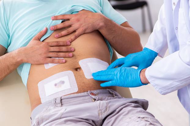 Injured young man visiting experienced male doctor