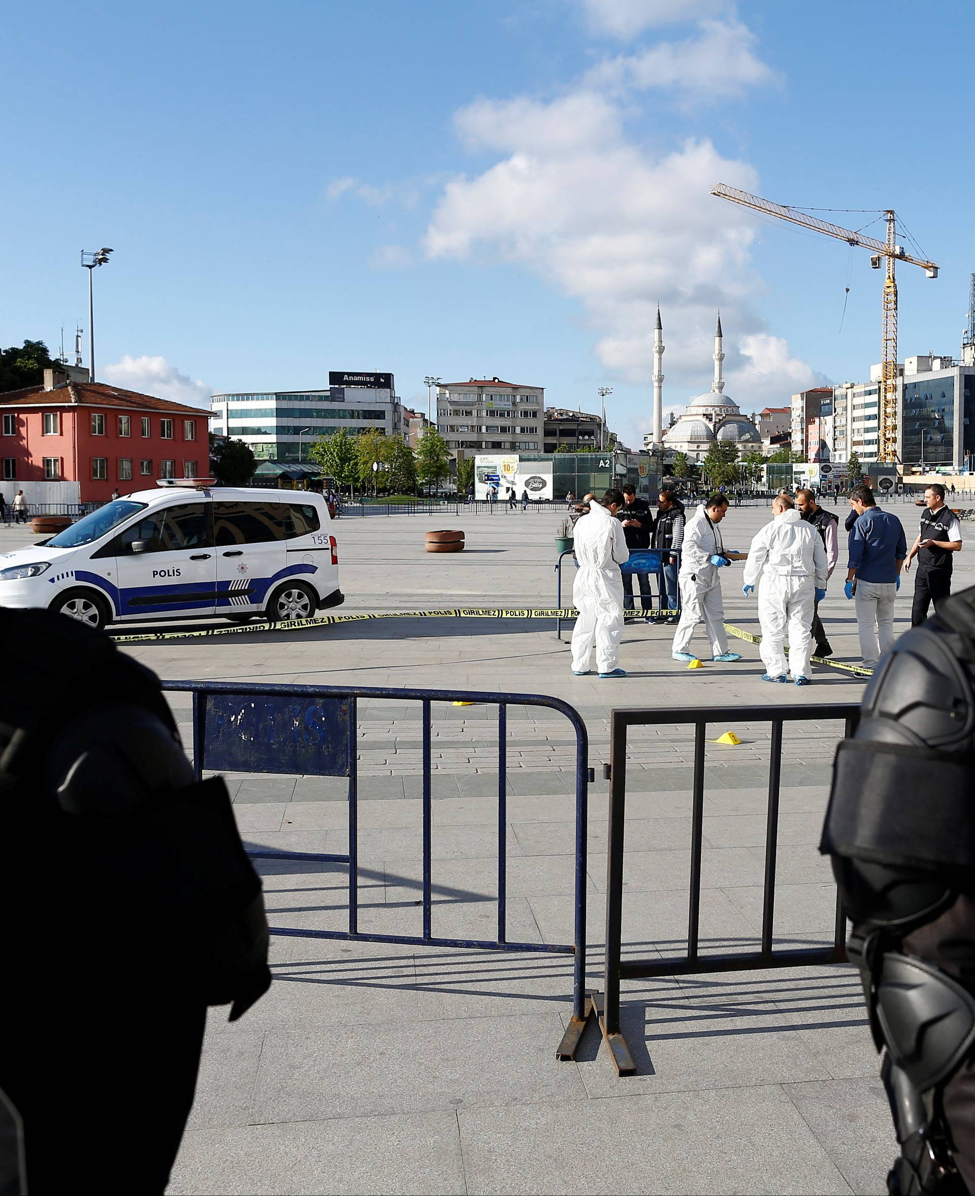Turkish riot policemen secure the area as forensic officers inspect the area after an attack aganist Can Dundar, editor-in-chief of Cumhuriyet in front of the Justice Palace in Istanbul