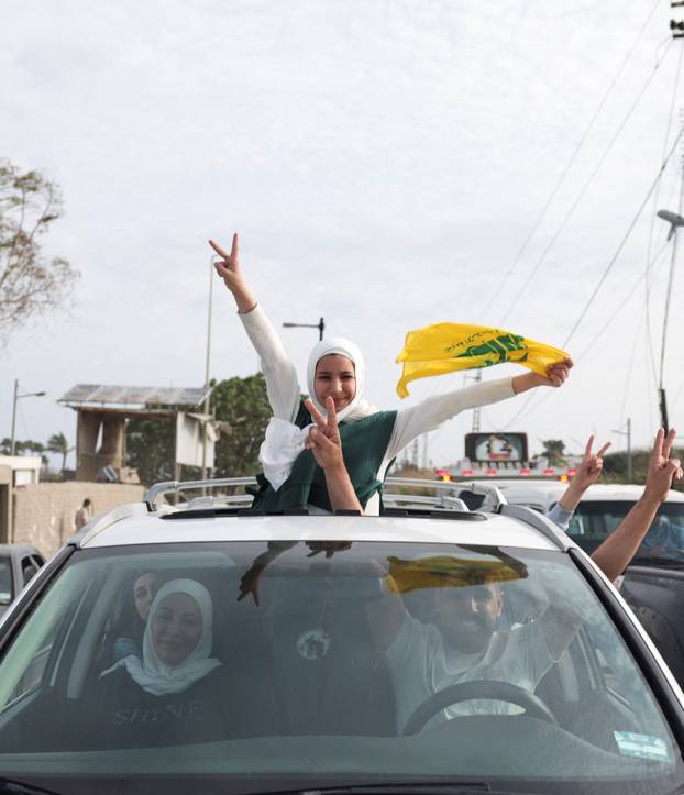 Displaced people cross the bridge linking southern Lebanon to the rest of the country, which was hit earlier in an Israeli strike, in Qasmiyeh