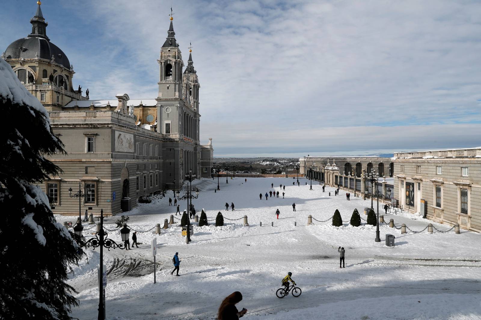 People walk in the snow outside La Almudena Cathedral in Madrid