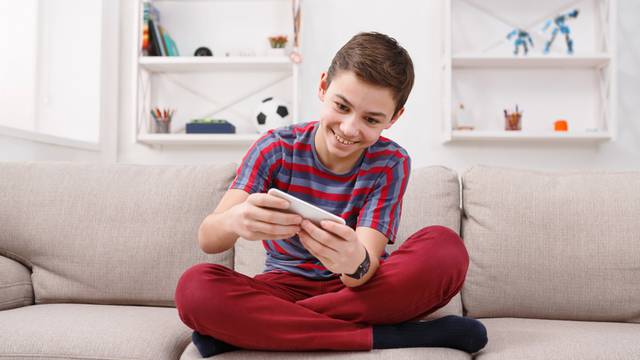 Teenager playing games on smartphone