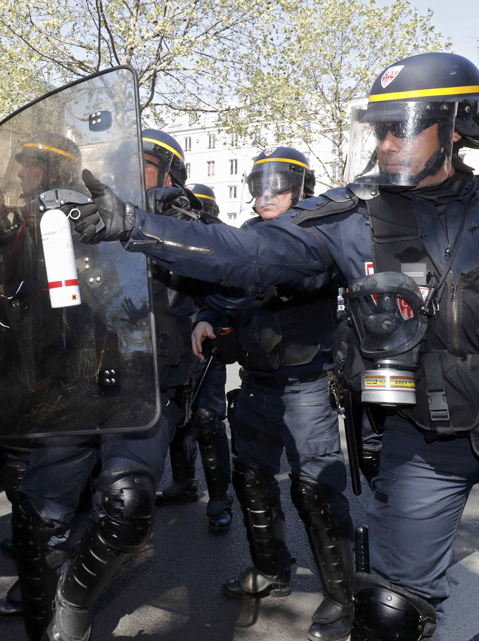 French CRS riot police use spray to push back youths who protest against the French labour law proposal during the May Day labour union march in Paris