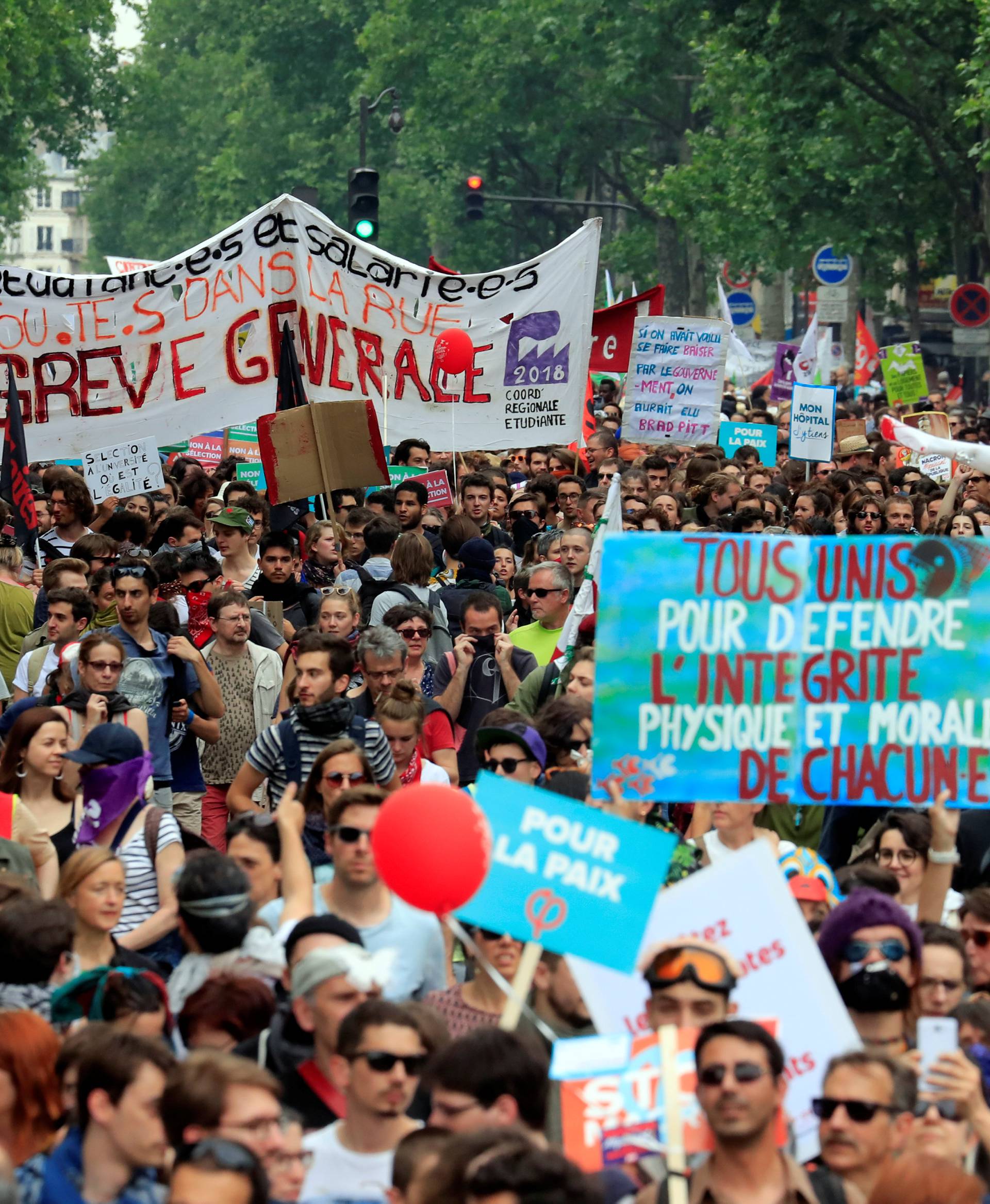 Protesters hold placards during a demonstration by French unions and France Insoumise" (France Unbowed) political party to protest against government reforms, in Paris