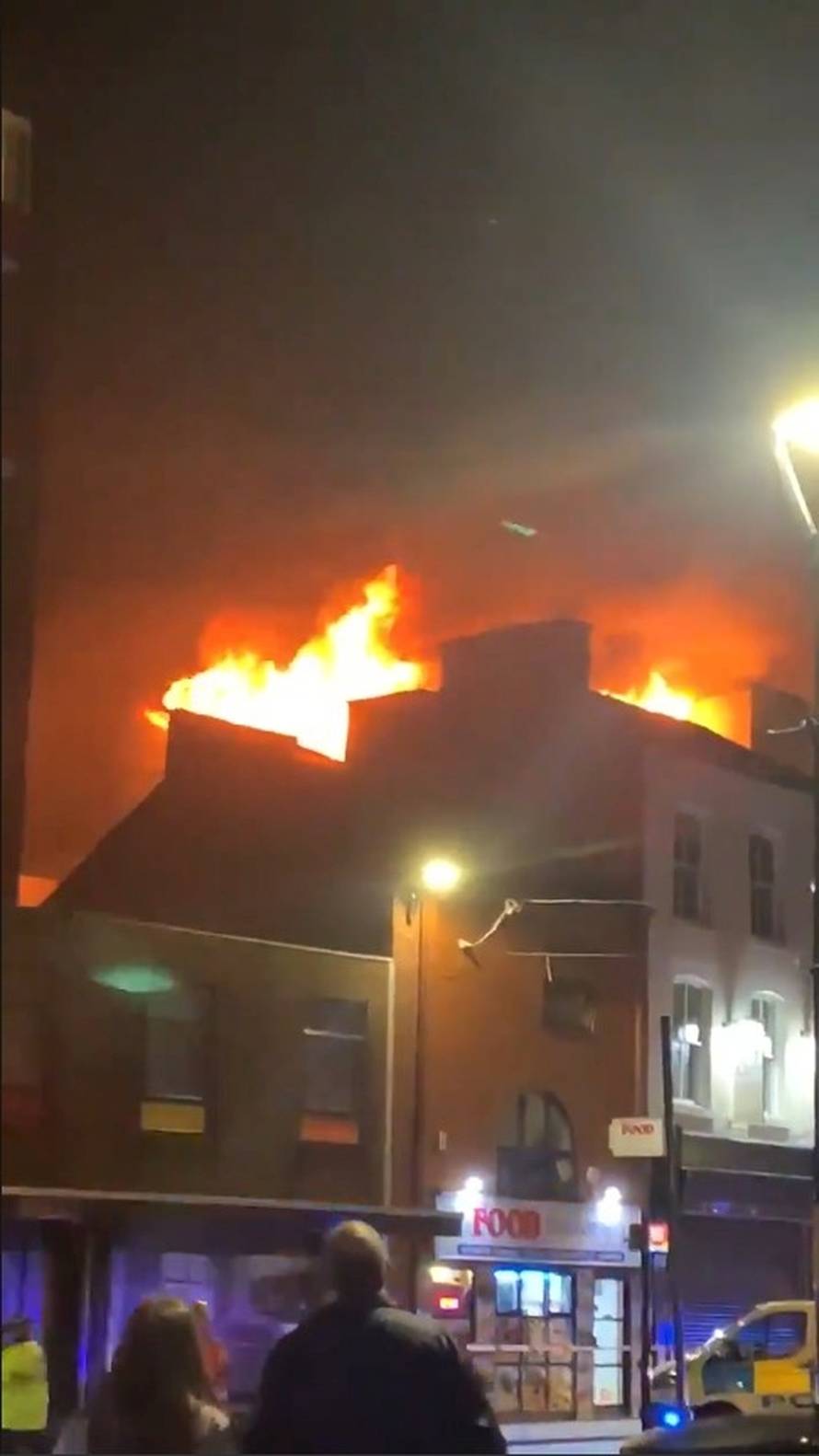 People watch a fire at a student accommodation building at the University of Bolton