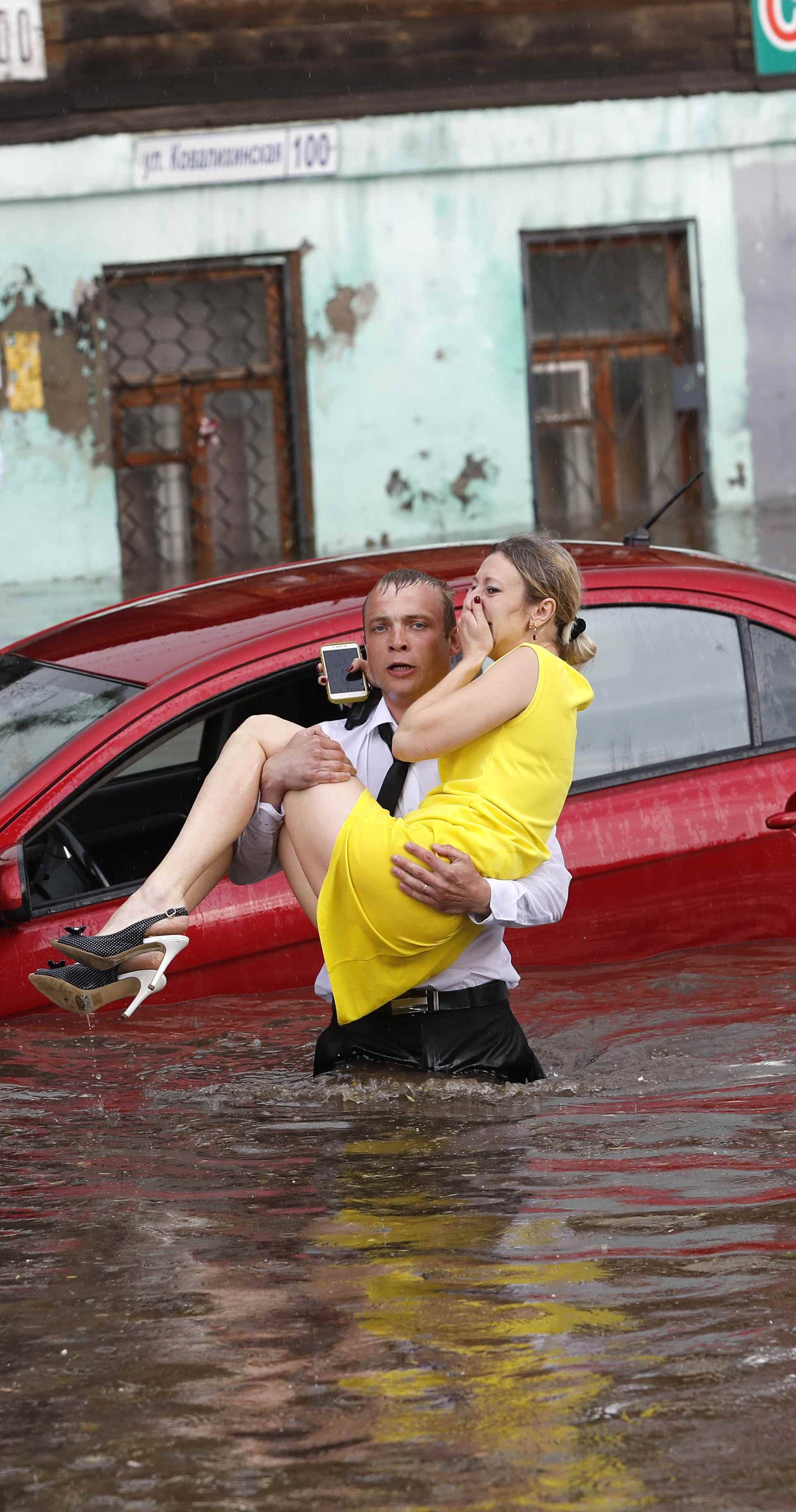 A woman is rescued from her flooded car at the street in Nizhny Novgorod