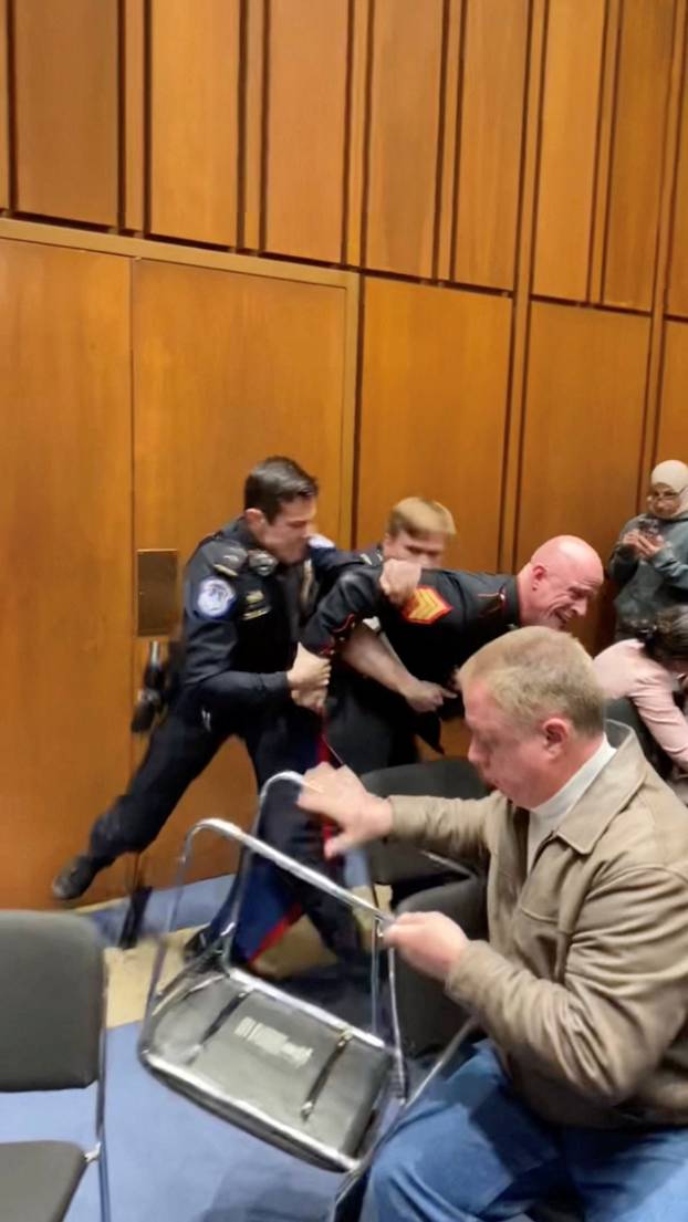 Former Marine Sgt. Brian McGuinness is dragged out during the Senate Armed Services subcommittee hearing, in Washington
