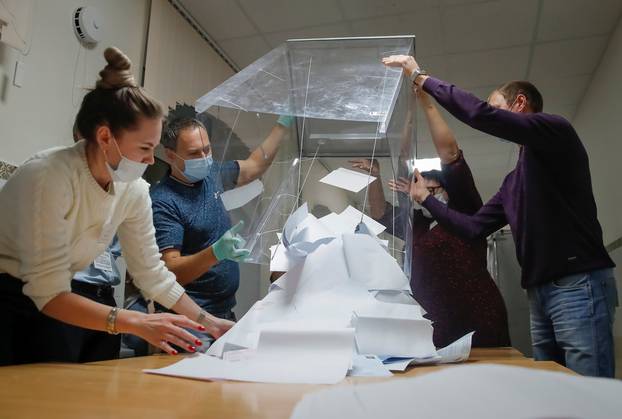 Members of a local electoral commission empty a ballot box to start counting ballots at a polling station after polls closed for municipal elections in Tomsk