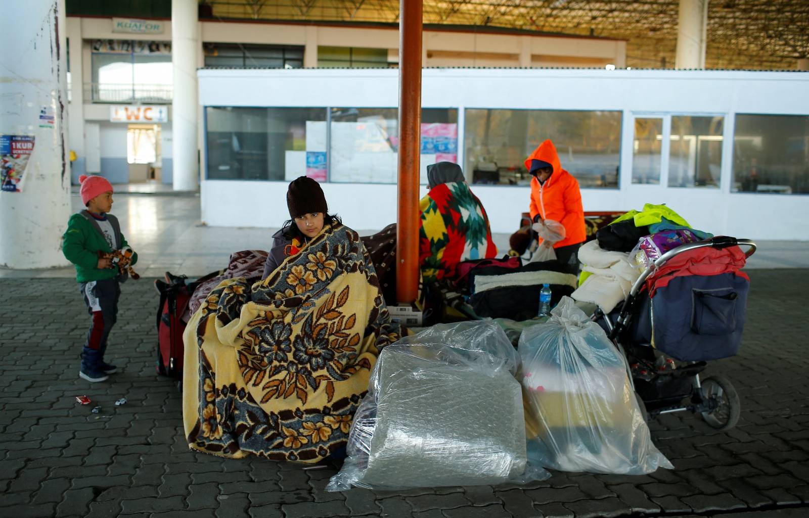 Migrants rest near Turkey's Pazarkule border crossing with Greece's Kastanies, near Edirne