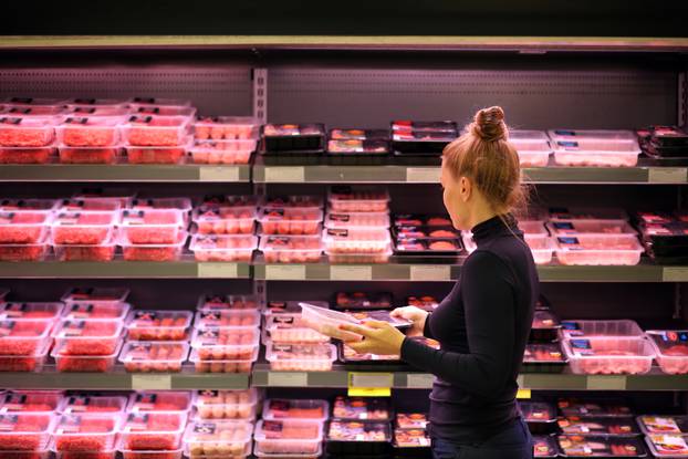 Woman,Purchasing,A,Packet,Of,Meat,At,The,Supermarket