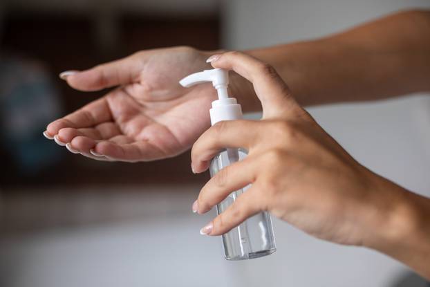 Close up view of woman person using small portable antibacterial