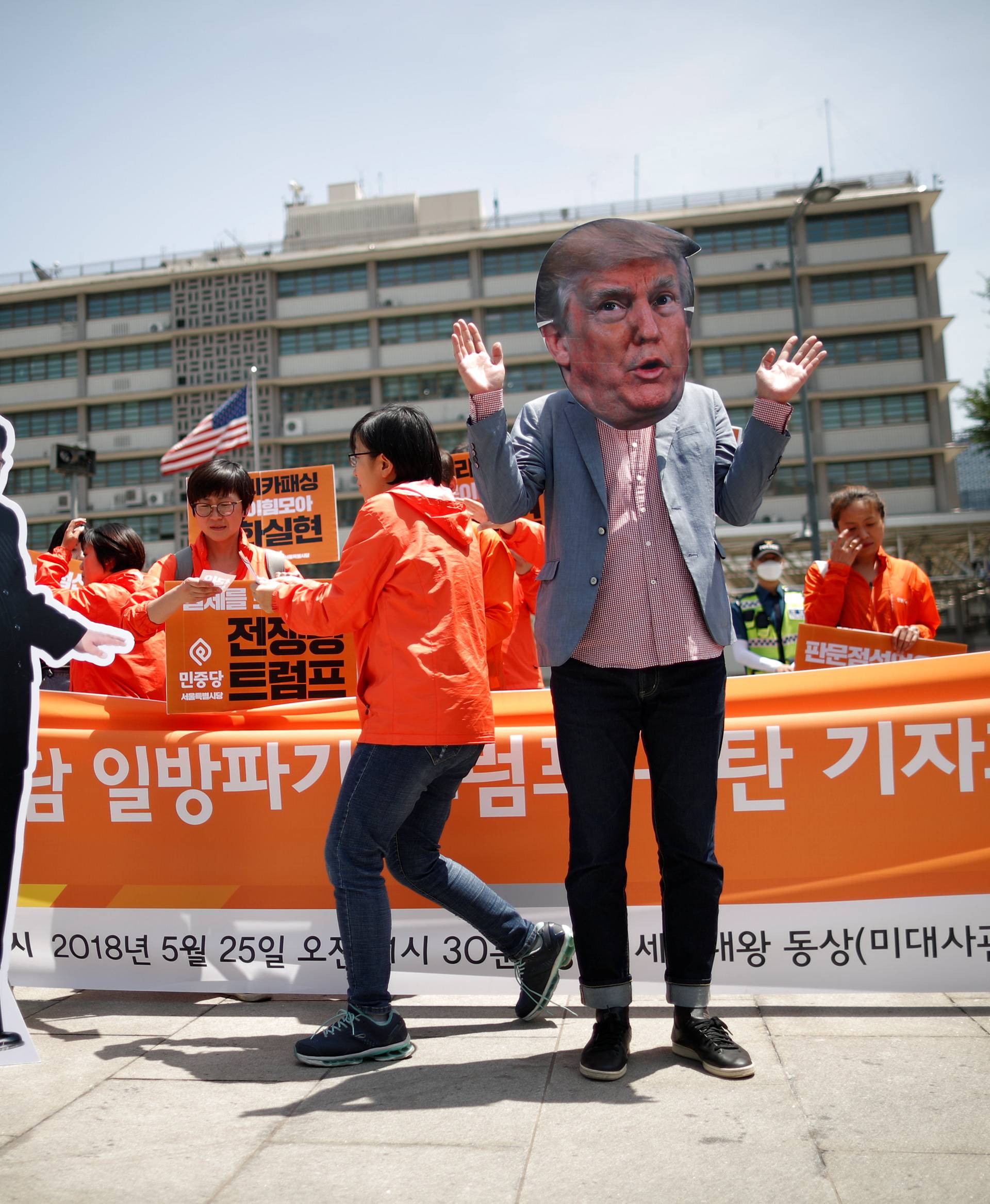 A man wearing a mask of U.S. President Donald Trump performs next to a cutout of North Korean leader Kim Jong Un during an anti-U.S. President Donald Trump rally near U.S. embassy in Seoul