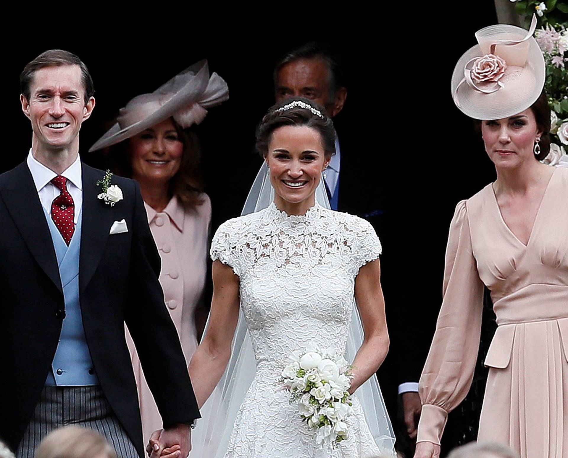 Pippa Middleton and James Matthews smile as they are joined by Britain's Catherine, Duchess of Cambridge after their wedding at St Mark's Church in Englefield