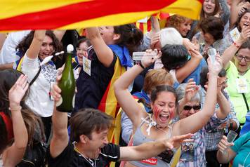 People celebrate after the Catalan regional parliament passes the vote of independence from Spain in Barcelona