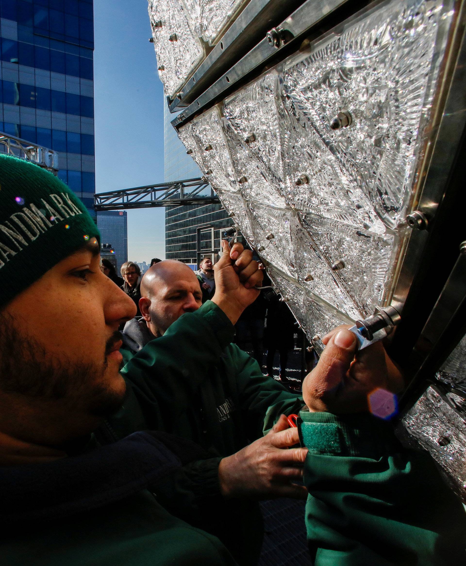 Workers install Waterford Crystal triangles on the Times Square New Year's Eve Ball on the roof of One Times Square in the Manhattan borough of New York