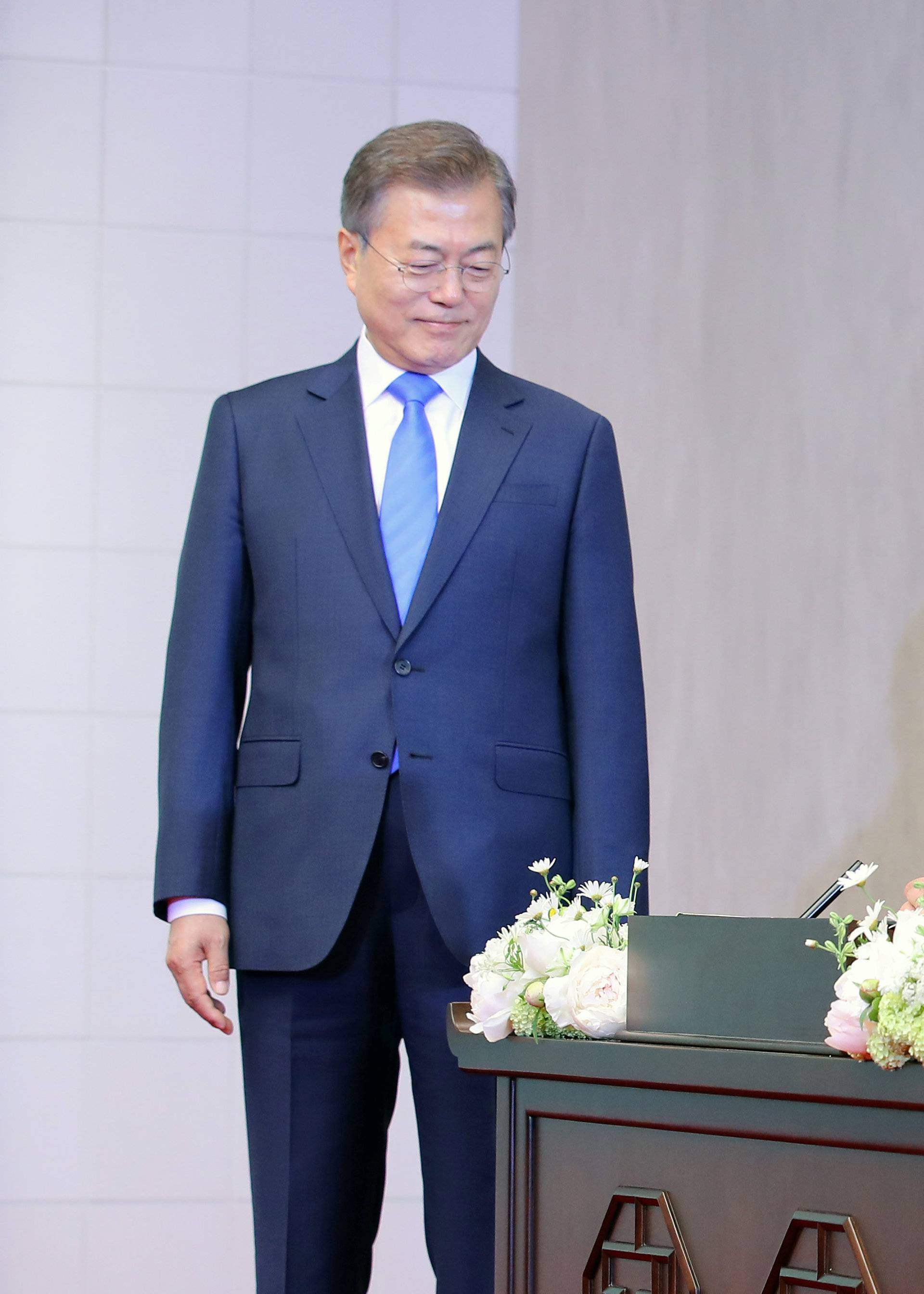 South Korean President Moon Jae-in watches as North Korean leader Kim Jong Un writes in a guestbook during their meeting at the Peace House