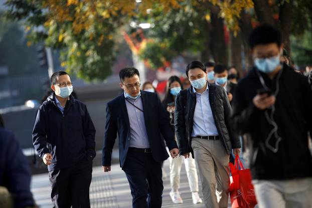 People wearing masks following the coronavirus disease (COVID-19) outbreak are seen on a street during morning rush hour in Beijing