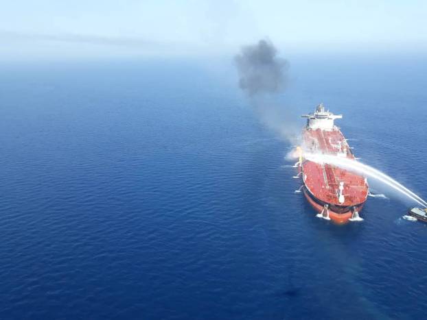 An Iranian navy boat tries to stop the fire of an oil tanker after it was attacked in the Gulf of Oman