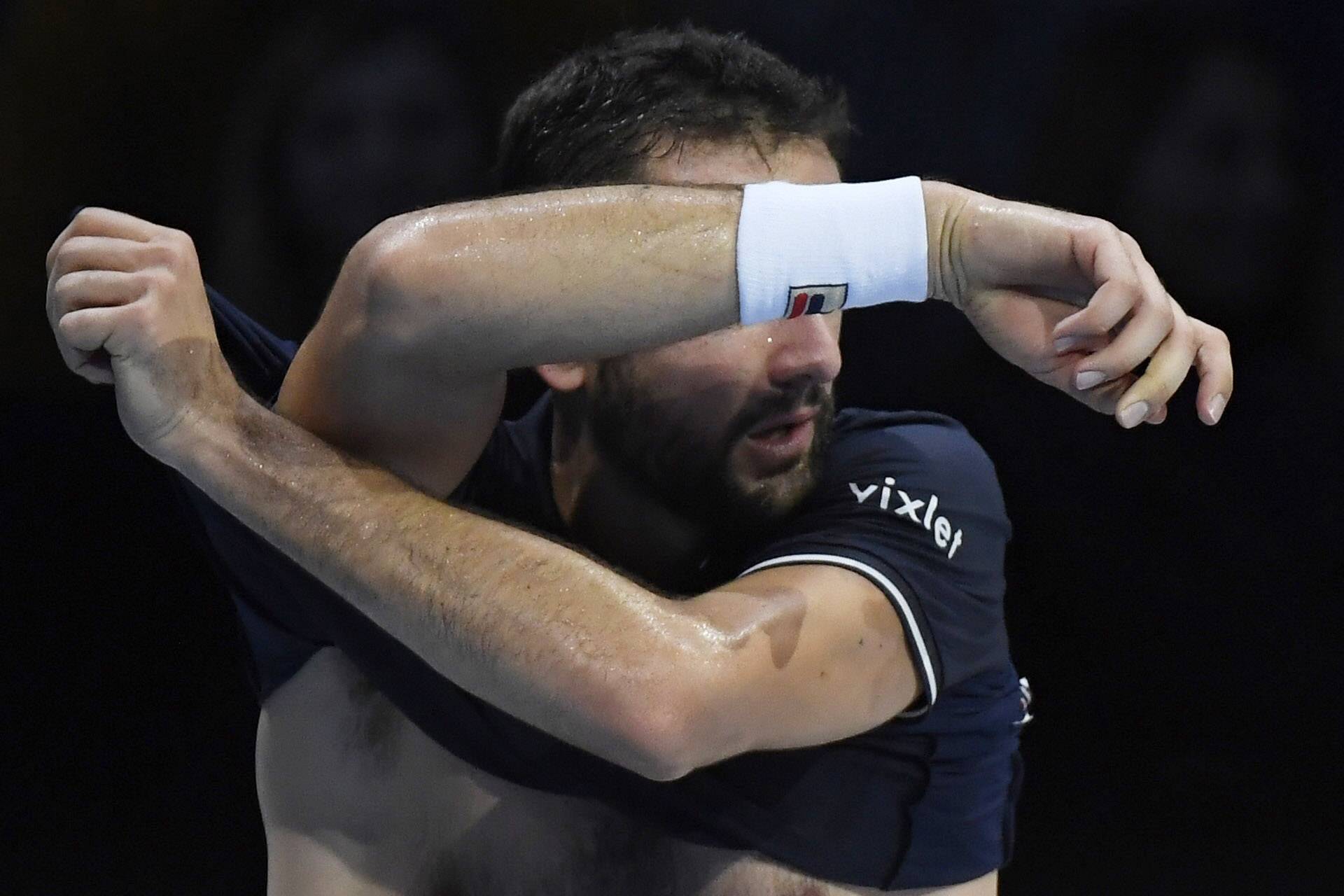 Croatia's Marin Cilic changes his shirt during his round robin match with Switzerland's Stanislas Wawrinka