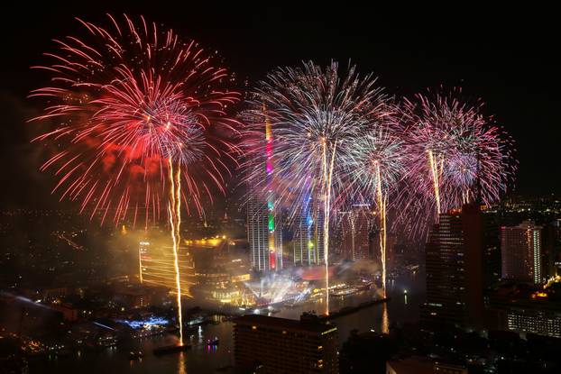 Fireworks explode over Chao Phraya River during the New Year celebrations in Bangkok