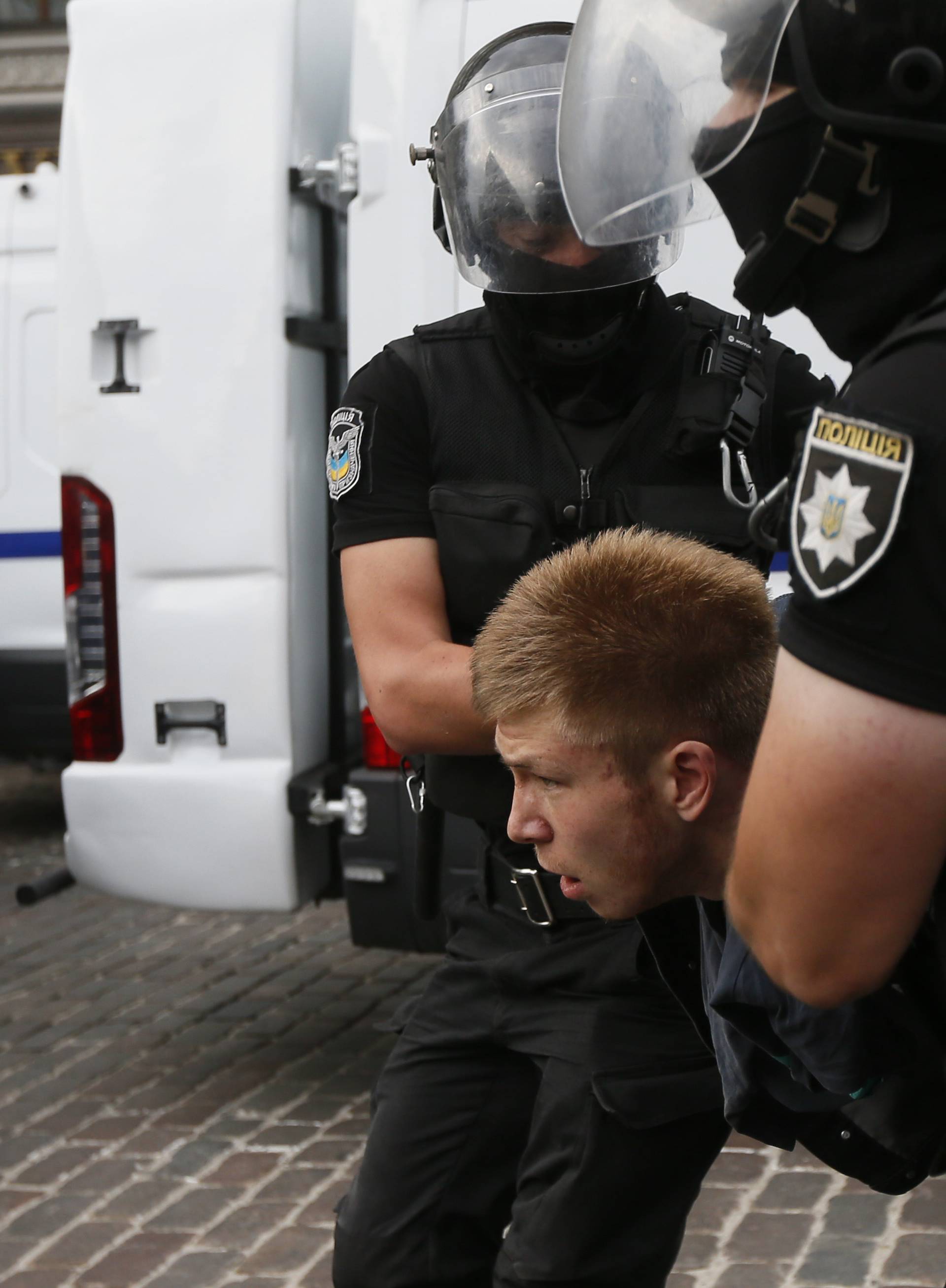 Riot police officers detain an anti-LGBT protesters during the Equality March in Kiev