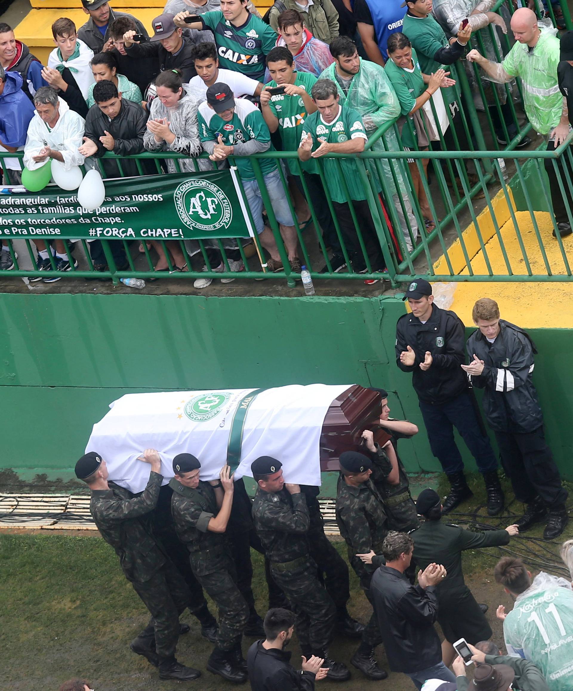 Soldiers carry out the coffin of one of the victims of the plane crash in Colombia at Arena Conda stadium during a ceremony to pay tribute to them in Chapeco