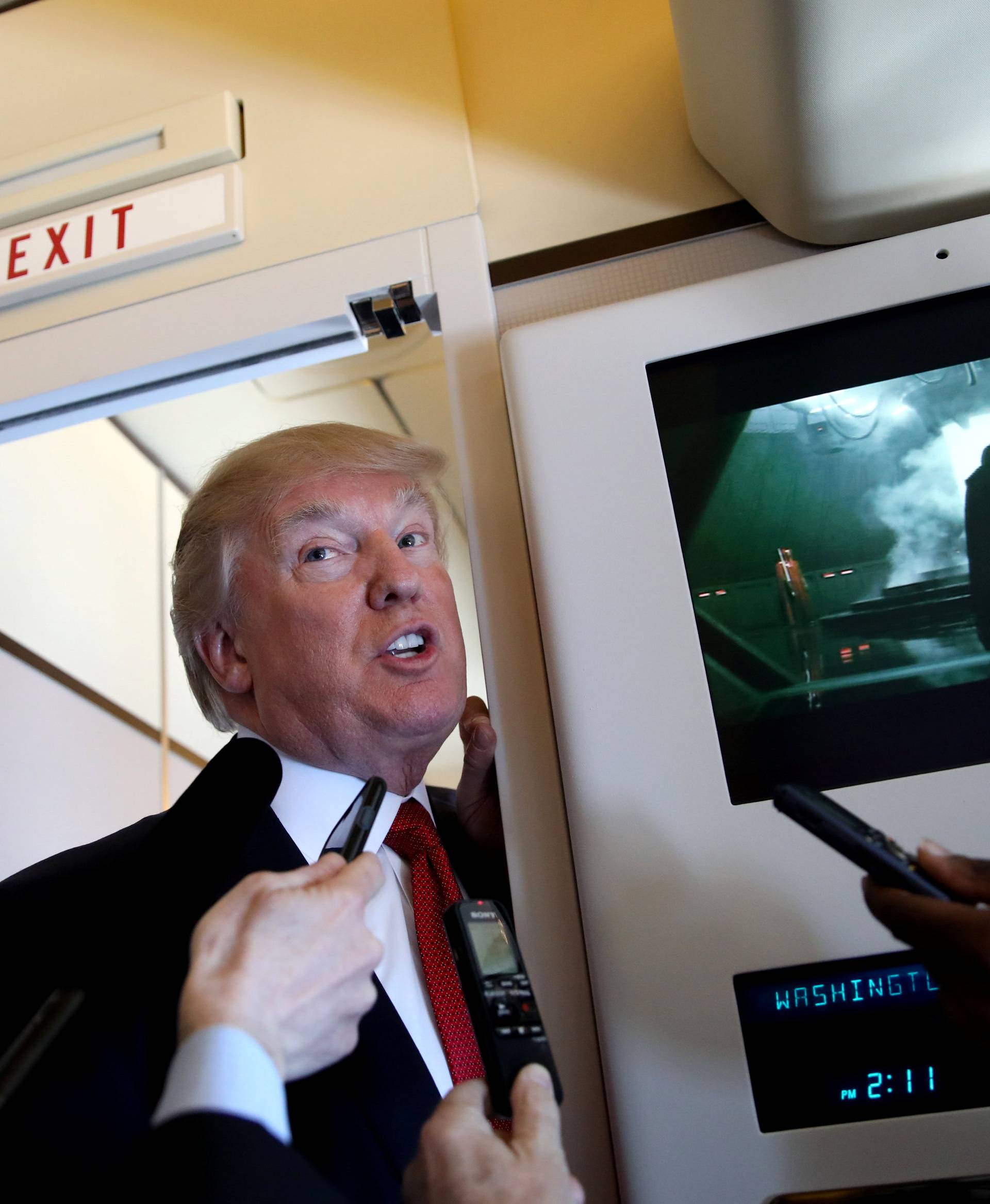 U.S. President Donald Trump talks to journalists, members of the travel pool, on board of Air Force One during his trip to Palm Beach