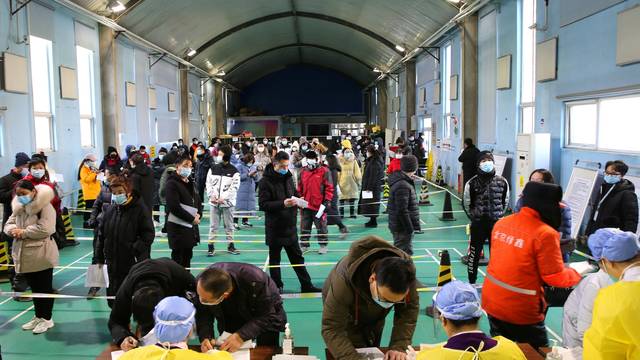 People line up to receive vaccine against COVID-19 at a sports centre in Beijing's Haidian district