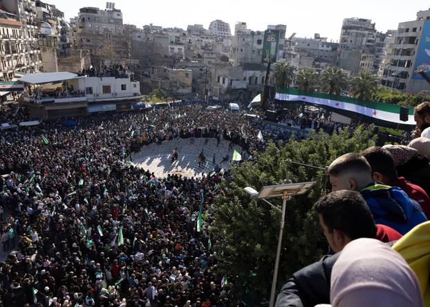 People celebrate after ousting of Syria's Bashar al-Assad, during a gathering after Friday prayers in Latakia