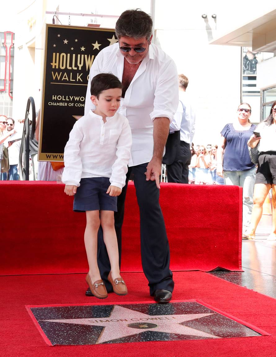Television producer Cowell and his son Eric pose on his star on the Hollywood Walk of Fame in Los Angeles